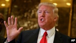 President-elect Donald Trump speaks with reporters in the lobby of Trump Tower in New York, Friday, Jan. 13, 2017. (AP Photo/Evan Vucci)