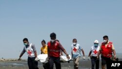 Members of the Myanmar Red Cross carry a dead body of a driver from a boat in Sittwe, Rakhine State 