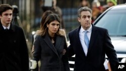 Michael Cohen ki t ap kite tribinal la ak yon pititfi li Samantha (nan mitan) epi yon pititgason li, Jake, bò kote li.