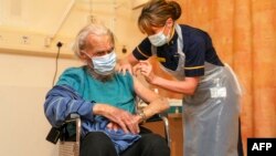 88 year old Trevor Cowlett receives the Oxford University/AstraZeneca COVID-19 vaccine from nurse Sam Foster at the Churchill Hospital in Oxford, southwest England on January 4, 2021. - Britain today began the mass rollout of the Oxford-AstraZeneca corona