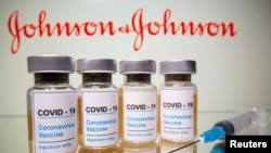 FILE PHOTO: Vials and medical syringe are seen in front of J&J logo in this illustration