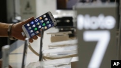 A customer holds a Samsung Electronics Galaxy Note 7 smartphone at the headquarters of South Korean mobile carrier KT in Seoul, South Korea, Friday, Sept. 2, 2016.