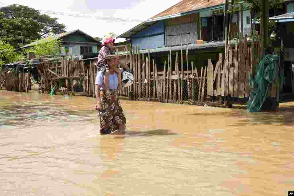 နေပြည်တော်မှာ တိုင်ဖွန်း Yagi (ရာဂီ) ကြောင့် ရေကြီးနေတဲ့လမ်းတခုကြား သွားလာနေတဲ့ အမျိုးသမီးနဲ့ ကလေးငယ်တဦးကိုတွေ့ရစဉ် (စက်တင်ဘာ ၁၇၊ ၂၀၂၄)