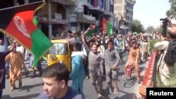 People carry Afghan flags as they take part in an anti-Taliban protest in Jalalabad, Afghanistan August 18, 2021 in this screen grab taken from a video. (Pajhwok Afghan News/Handout via REUTERS)