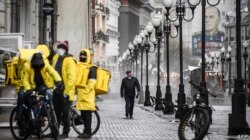 Moskova'daki ünlü Arbat Caddesi'nde yemek dağıtan kuryeler sıra bekliyor