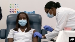 Sandra Lindsay, left, a nurse at Long Island Jewish Medical Center, is inoculated with the Pfizer-BioNTech COVID-19 vaccine