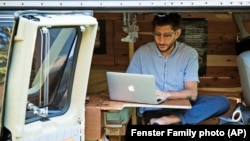 FILE - In this 2018 photo, Danny Fenster works out of his van that he made into a home/office in Detroit, Michigan.