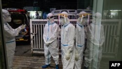 This photo taken on October 9, 2020 shows volunteer wearing personal protective equipment (PPE) following the transfer of people suspected of having COVID-19 coronavirus to a quarantine centre in Yangon. (Photo by Ye Aung THU / AFP)