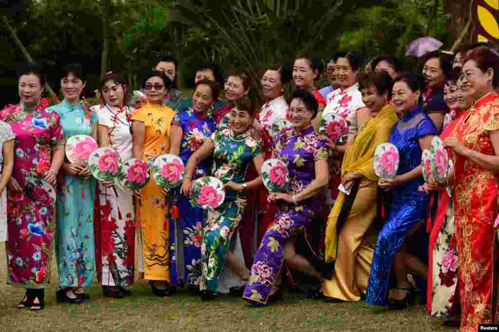 Women in cheongsams pose for photos during a Cheongsam Show ahead of International Women's Day in Qionghai, Hainan province, China