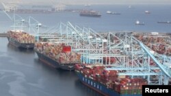 FILE - Containers are unloaded from ships at the Port of Long Beach-Port of Los Angeles complex in Los Angeles, California, April 7, 2021.