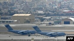 US soldiers walk through the tarmac to board an US Air Force aircraft at the airport in Kabul on August 30, 2021. - Rockets were fired at Kabul's airport on August 30 where US troops were racing to complete their withdrawal from Afghanistan and evacuate a