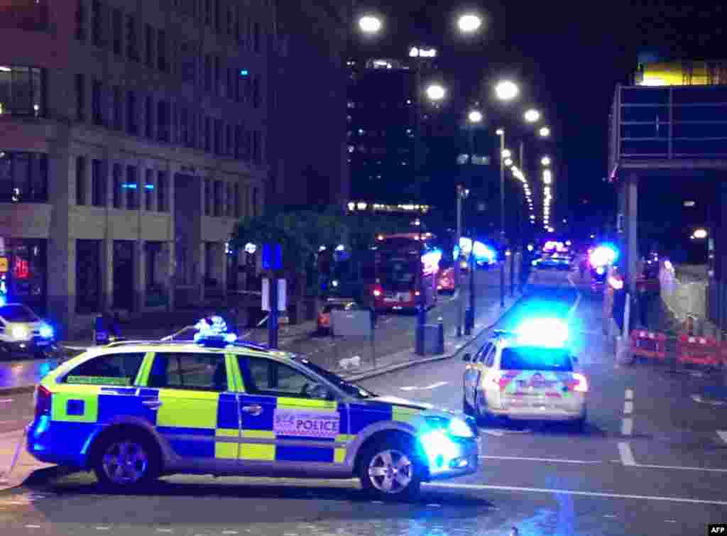 A photograph taken on a mobile phone shows British police cars blocking the entrance to London Bridge, in central London,June 3, 2017, following an incident on the bridge. Witnesses reported seeing a van mounting the pavement and hitting pedestrians.