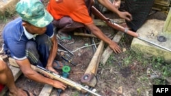 Members of the People's Defense Force (PDF) make handmade guns to be used in fighting against security forces near Demoso, Kayah state on June 4, 2021, as the country remains in turmoil after the February military coup. (Photo by STR / AFP)