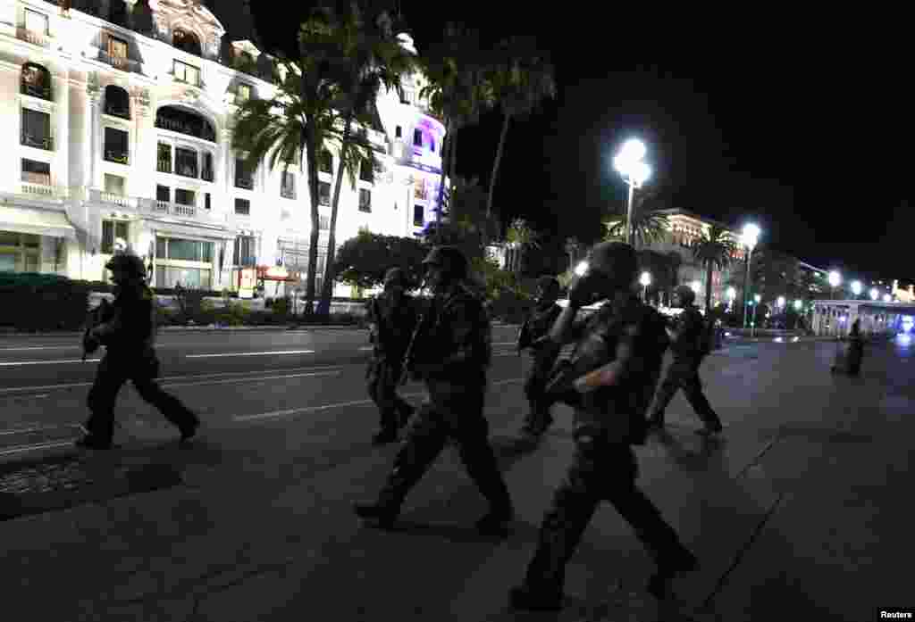 French soldiers advance on a street.