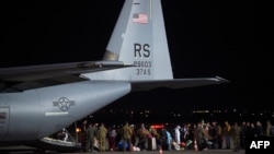 Afghan refugees, fleeing the capital Kabul, exit an US air force plane upon their arrival at Pristina International airport near Pristina on August 29, 2021.- Kosovo has offered to take in temporarily thousands of Afghan refugees evacuated by US flight.