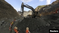 Miners search for jade stones at a mine dump at a Hpakant jade mine in Kachin state