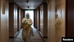 A staff worker disinfects a hotel floor inside the Olympic "closed-loop" during the Beijing 2022 Winter Olympics in Beijing, China, Feb. 8, 2022. 