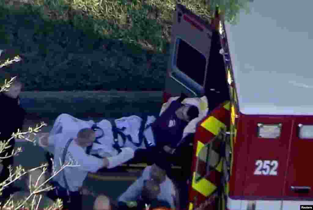 A man who was placed in handcuffs by police is loaded into a paramedic vehicle after a shooting incident at Marjory Stoneman Douglas High School in Parkland, Feb. 14, 2018 in a still image from video.