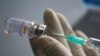 FILE PHOTO: A health worker holds a syringe and a vial of the Sinovac coronavirus disease (COVID-19) vaccine at a market in Bangkok, Thailand, March 17, 2021. REUTERS/Athit Perawongmetha/File Photo