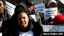 emonstrators hold signs and chant outside the Governors Mansion at the Capitol in Richmond, Va., as they call for the resignation of Virginia Governor Ralph Northam after photo of a person wearing blackface was discovered in his medical school yearbook.