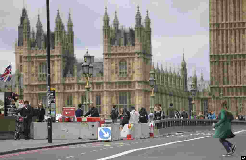 Pedestrians walk by newly installed barriers on Westminster Bridge in London, June 5, 2017.