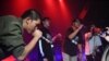 An audience member, second from right, raps with members of Rap Against Dictatorship on stage in Bangkok, Oct. 27, 2018. The group has touched a nerve with an impassioned and now-viral music video lobbing fiery rhymes at the ruling junta.