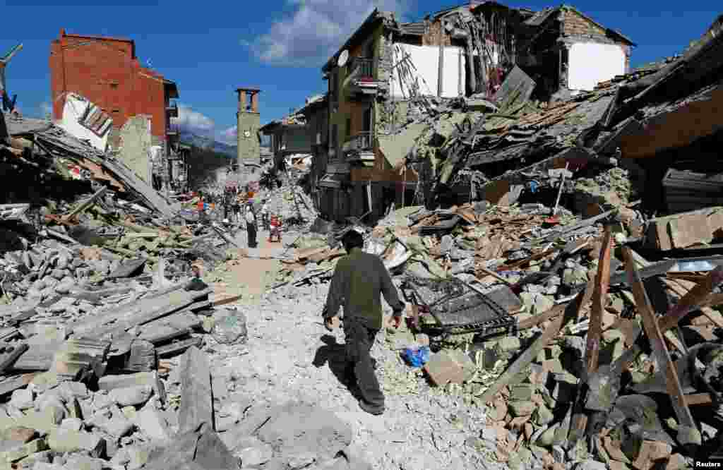 A man walks amidst rubble following an earthquake in Pescara del Tronto, central Italy, Aug. 24, 2016. 