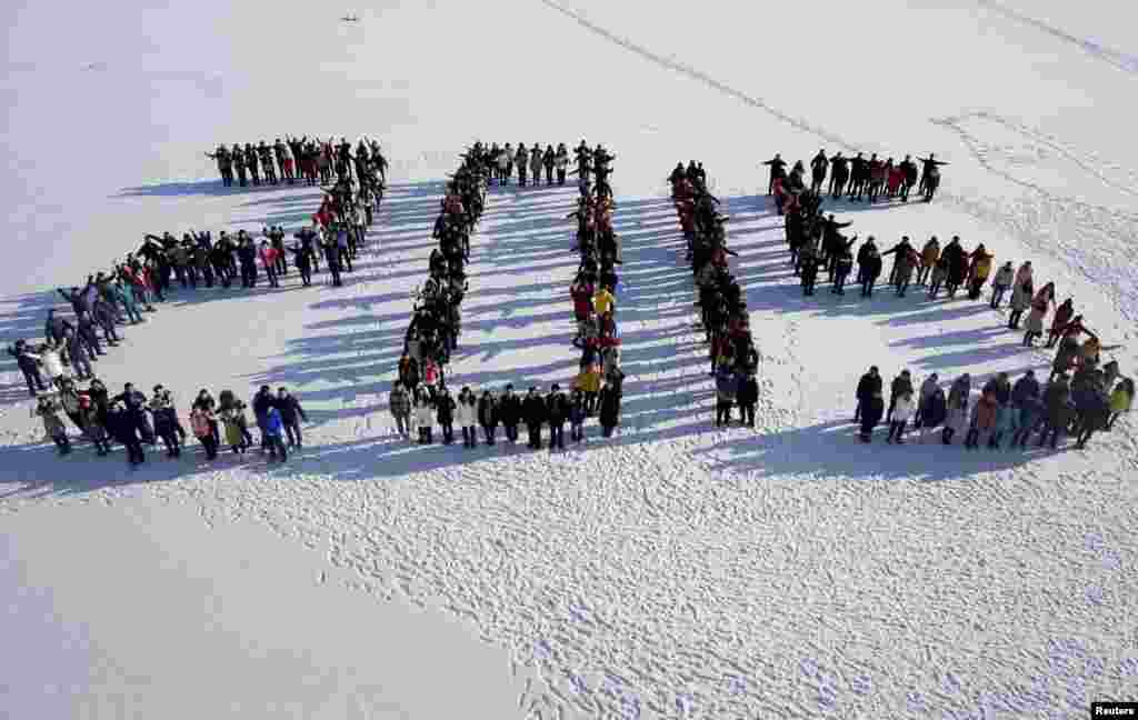 Students form &quot;2015&quot; standing on snow to welcome the upcoming New Year at Shenyang Agriculture University in Shenyang, Liaoning province, China, Dec. 31, 2014.