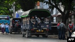 Police prepare to search for protesters, who were taking part in a demonstration against the military coup, in downtown Yangon on May 6, 2021. (Photo by STR / AFP)