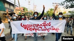 Students hold a banner and flash the three-finger salute as they take part in a protest against Myanmar’s junta, in Mandalay, Myanmar May 10, 2021. REUTERS/Stringer NO RESALES. NO ARCHIVES