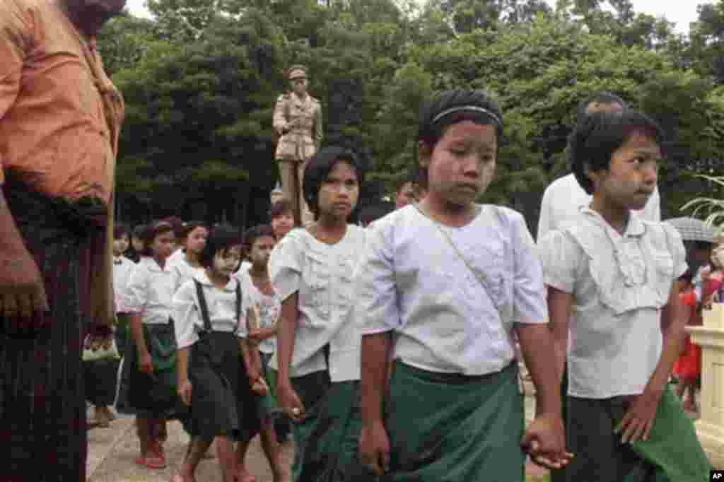  School children leave after paying a visit to the statue of Gen. Aung San, the late father of Myanmar opposition leader Aung San Suu Kyi, during a ceremony to mark the 68th anniversary of his 1947 assassination, at a park in Yangon, Myanmar, Sunday, July