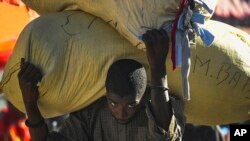 A vendor carries his bags of clothing for several blocks to his market stall, instead of using a tap tap bus due to a fuel shortage, in Port-au-Prince, Haiti, Nov. 11, 2021. 