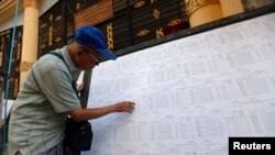 A man searches for his name through lists of voters outside an election commission office in Yangon November 4, 2010. Myanmar will hold its first parliamentary election in two decades on November 7, although critics say it will simply cement the military'