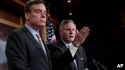 Sen. Mark Warner, D-Va., left, the vice chairman of the Senate Select Committee on Intelligence, and Chairman Richard Burr, R-N.C., right, speak to reporters about their panel's investigation of Russian interference in the 2016 election, on Capitol Hill, 