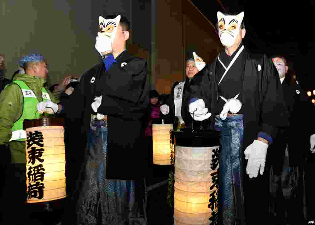 Residents in fox masks participate in the Oji Fox parade to thank the outgoing and welcome the incoming year at the Oji Inari shrine in Tokyo, Japan, Jan. 1, 2018.