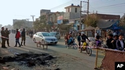 Police officers stand guard at the site where a Sri Lankan citizen was lynched by Muslim mob outside a factory in Sialkot, Pakistan, Dec. 3, 2021. 