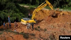 Rescuers work during a rescue and evacuation operation following a landslide at a campsite in Batang Kali