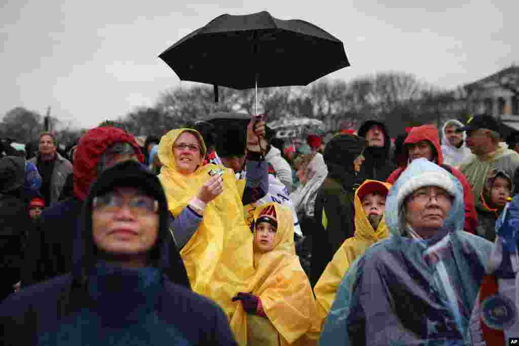 Spectators wait in the rain on the National Mall in Washington, Jan. 20, 2017, before the presidential inauguration of Donald Trump.