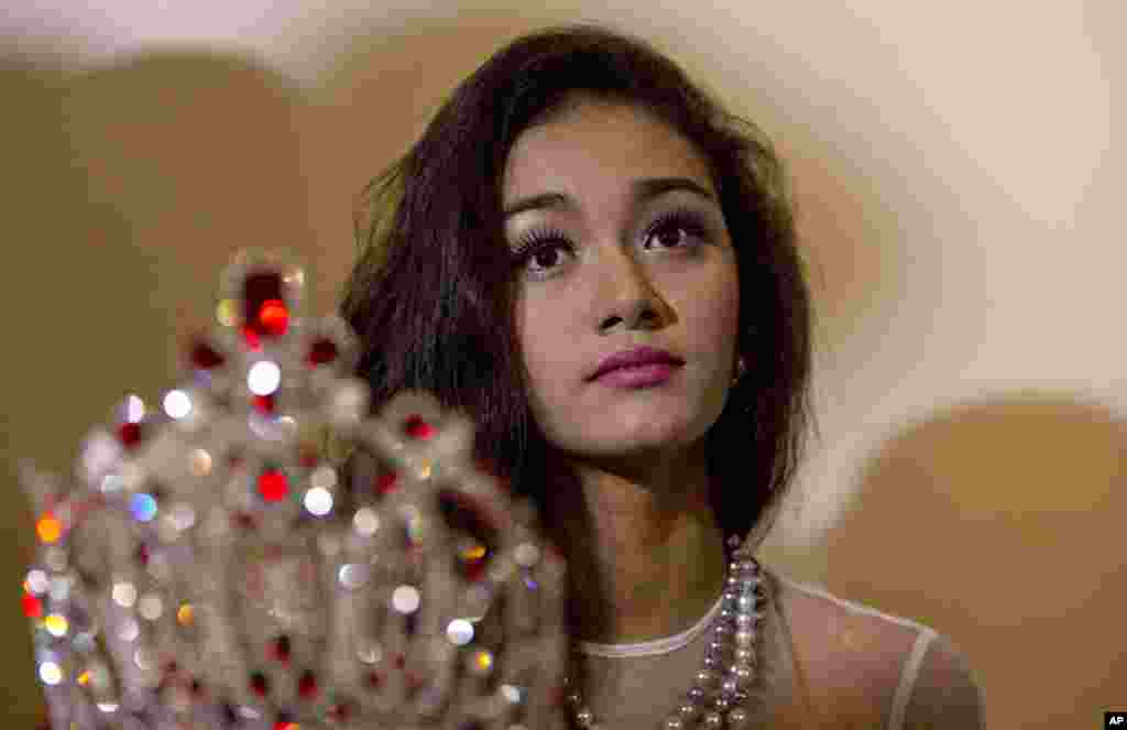 May Myat Noe, Myanmar's first international beauty queen, winner of the 2014 Miss Asia Pacific World, sits with her crown that she allegedly ran away with, during a press conference in Yangon, Myanmar, Sept. 2, 2014. 