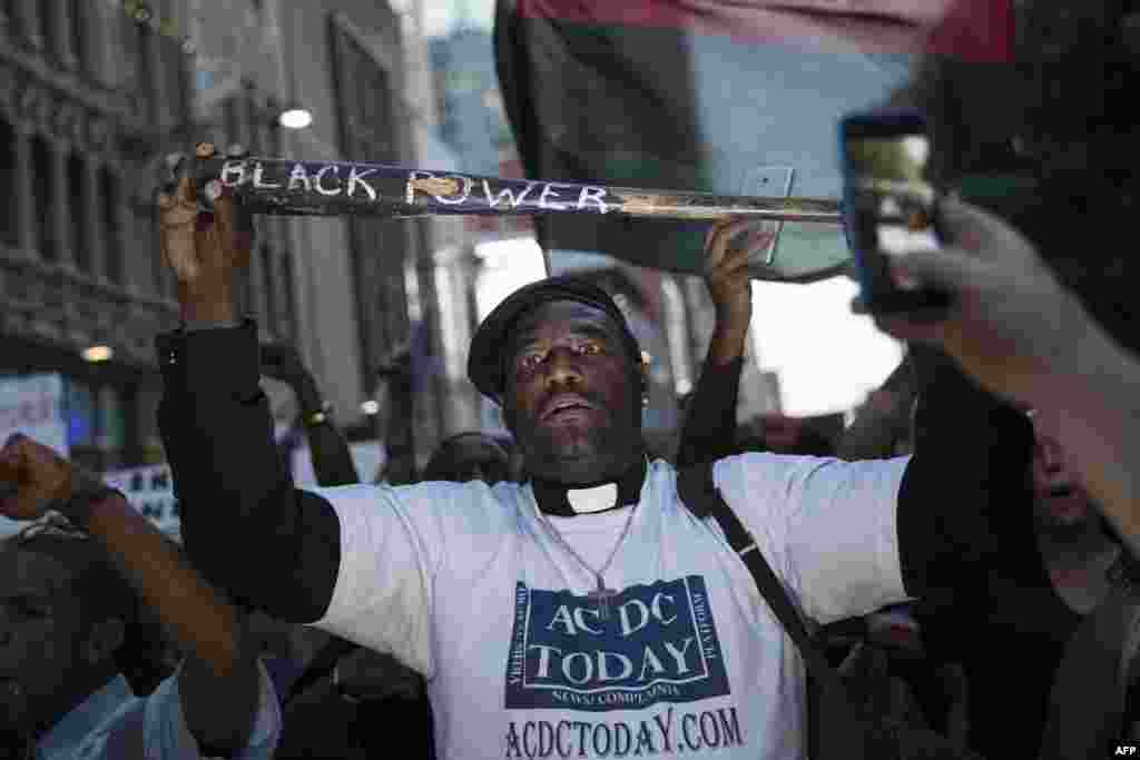 A man holds a bat reading "Black Power" during a protest in Dallas, Texas, on July 7, 2016 to protest the deaths of Alton Sterling and Philando Castile.