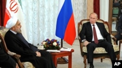 Russian President Vladimir Putin, right, speaks to Iran's President Hasan Rouhani during the Shanghai Cooperation Organization summit in Bishkek, Kyrgyzstan 