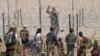 TOPSHOT - Migrant people seeking asylum in the US speak with a Texas National Guard agent after crossing the Rio Grande River in Ciudad Juarez, Chihuahua state, Mexico on March 13, 2024. (Photo by Herika Martinez / AFP)