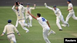 Australian cricket team bowler bowler Mitchell Starc celebrates with team mates after claiming his second hat-trick of the match to lead New South Wales to victory over Western Australia in the Sheffield Shield at Hurstville Oval in Sydney, Australia, Nov