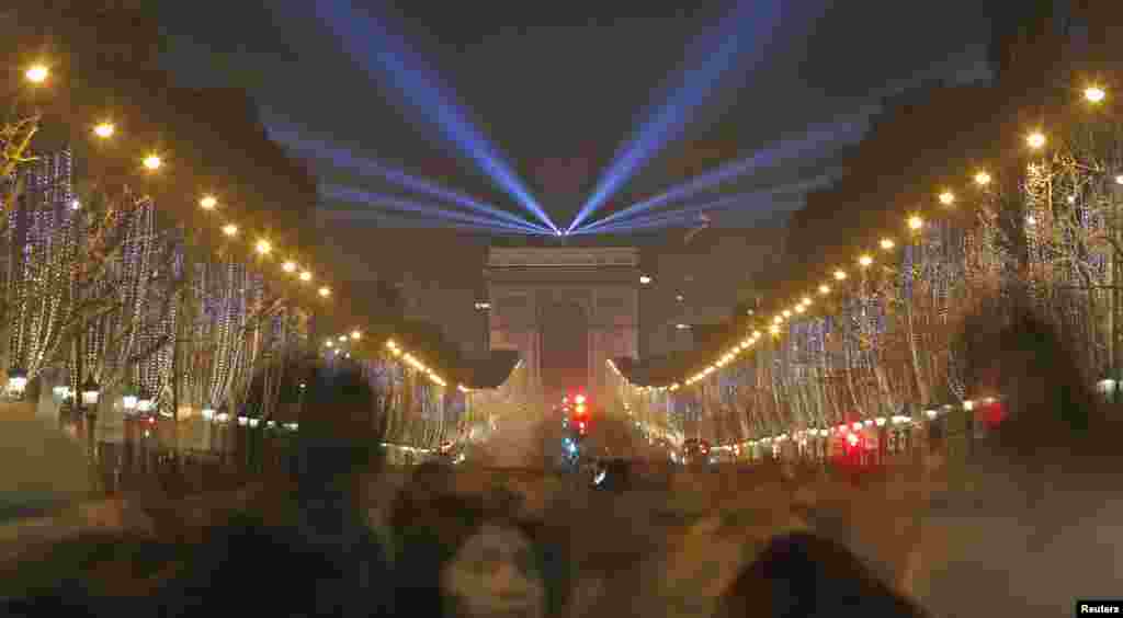 Revelers gather near the Arc de Triomphe on the Champs Elysees Avenue in Paris during New Year celebrations, Dec. 31, 2014.