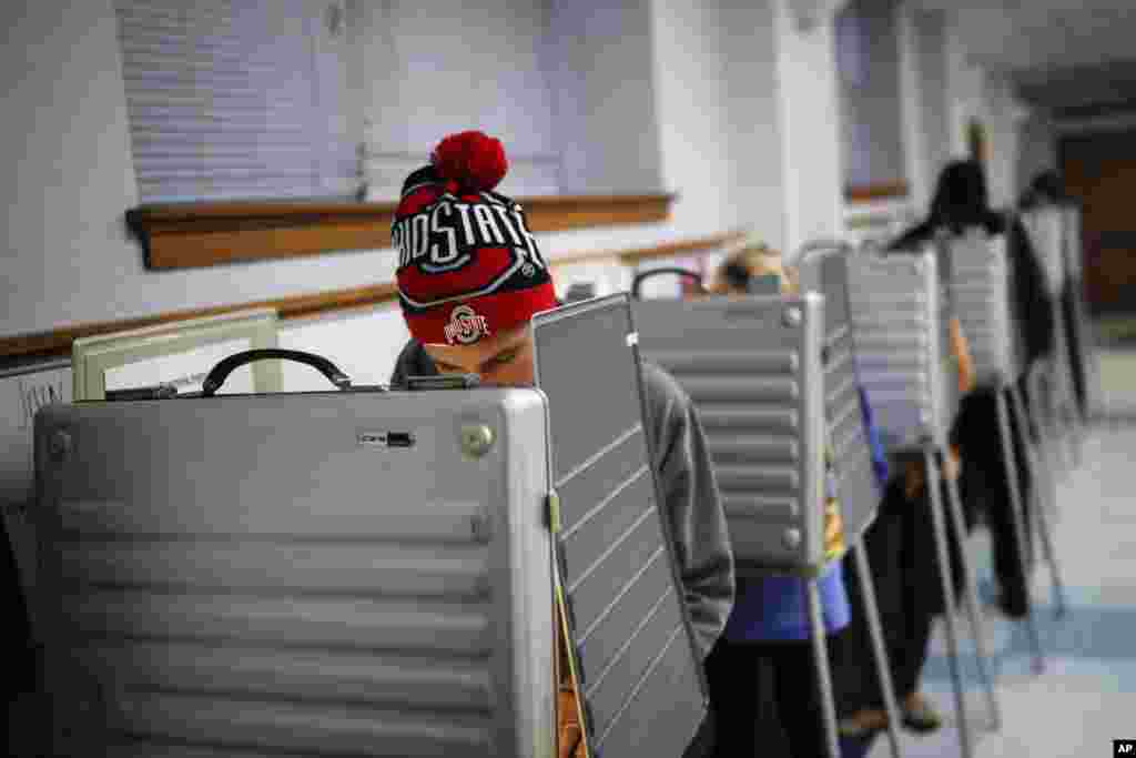 Sam Dugg fills out his ballot in a voting booth at the Nativity School on Election Day, Nov. 8, 2016, in Cincinnati. 