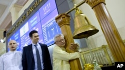 Serge Pun, right, executive chairman of First Myanmar Investment, joyfully hugs a bell pillar as electronic trading commence listing his company during the opening day of trading at Yangon Stock Exchange in Yangon, Myanmar, March 25, 2016. 